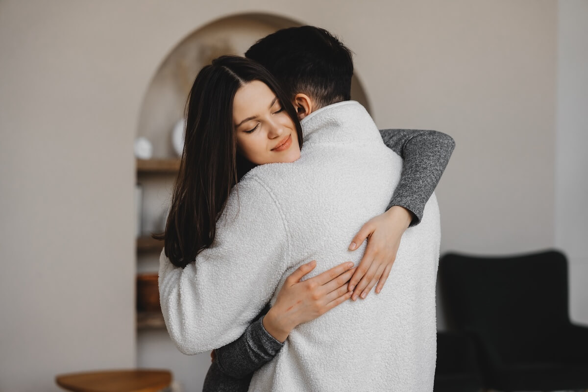 Shutterstock: Couple embraces in a cozy indoor setting during a quiet moment