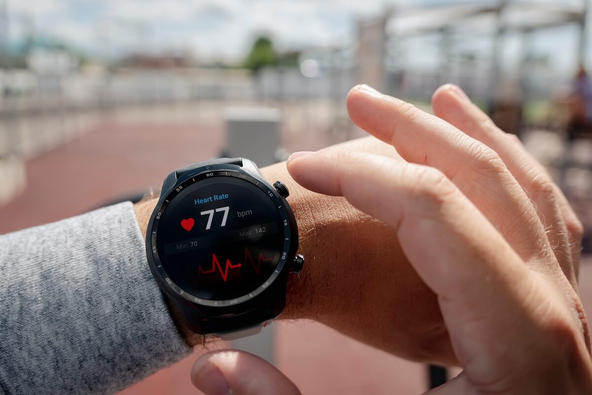 Shutterstock: Close-up of smart watch health tracker with the heart rate shown on the screen. Modern stylish and innovation wearable device. athlete checks his heart rate before training at the stadium. heart beat