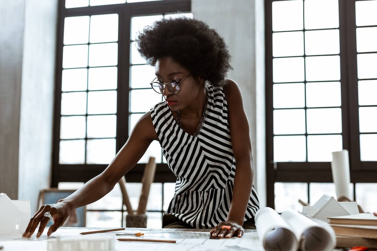 Shutterstock: Striped blouse. African-American interior designer wearing striped blouse working hard in the office