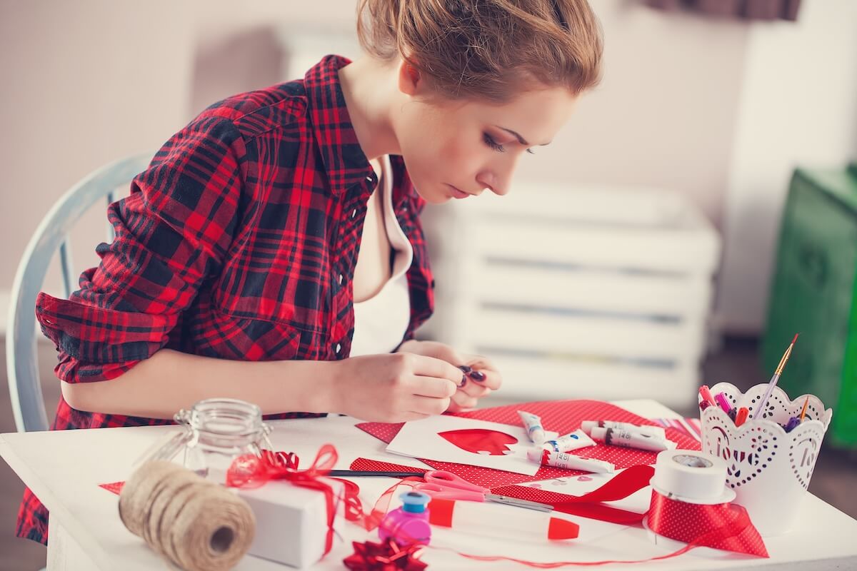 Shutterstock: Woman creating gift at home with paper and gouache