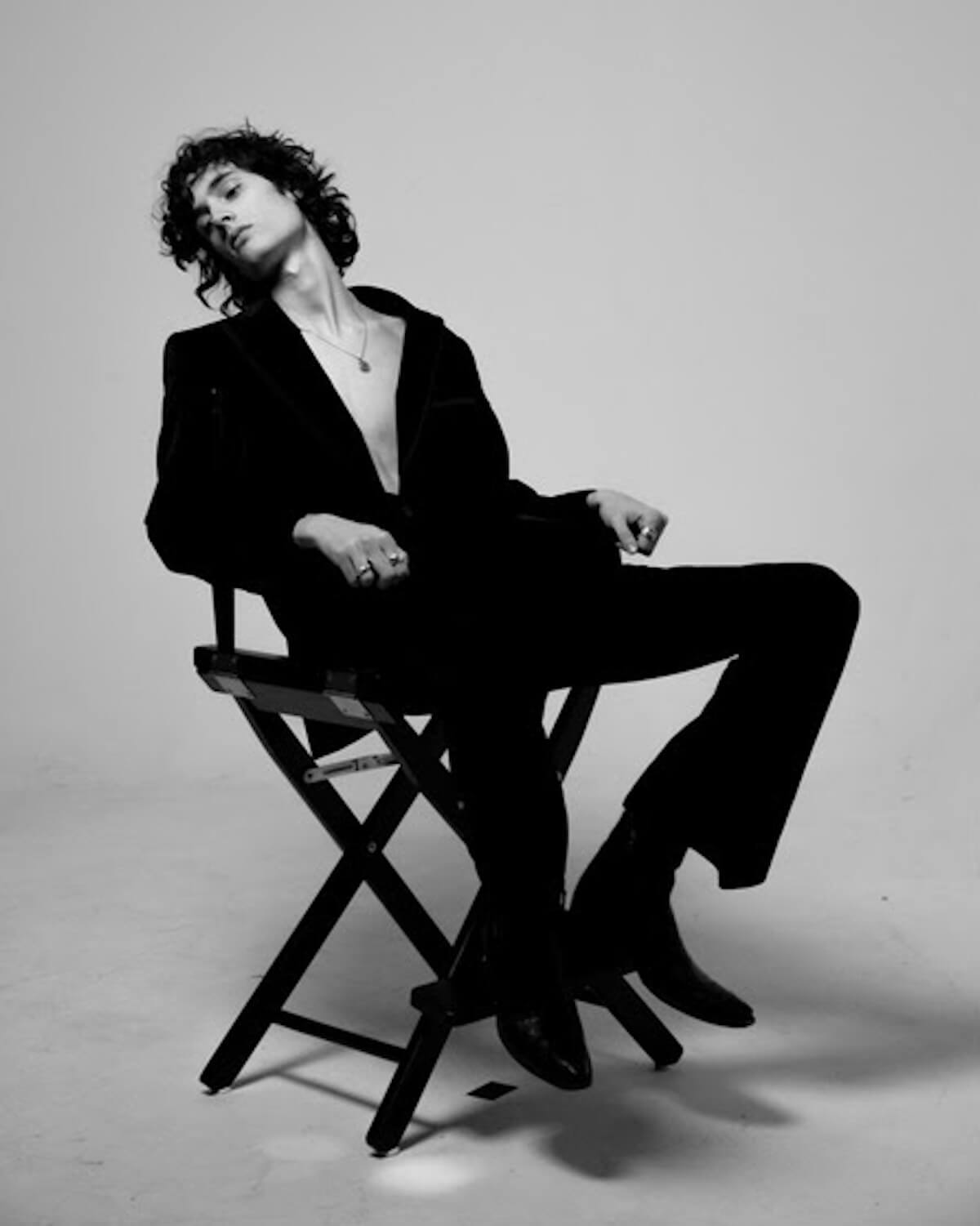 sombr black and white press image in directors chair