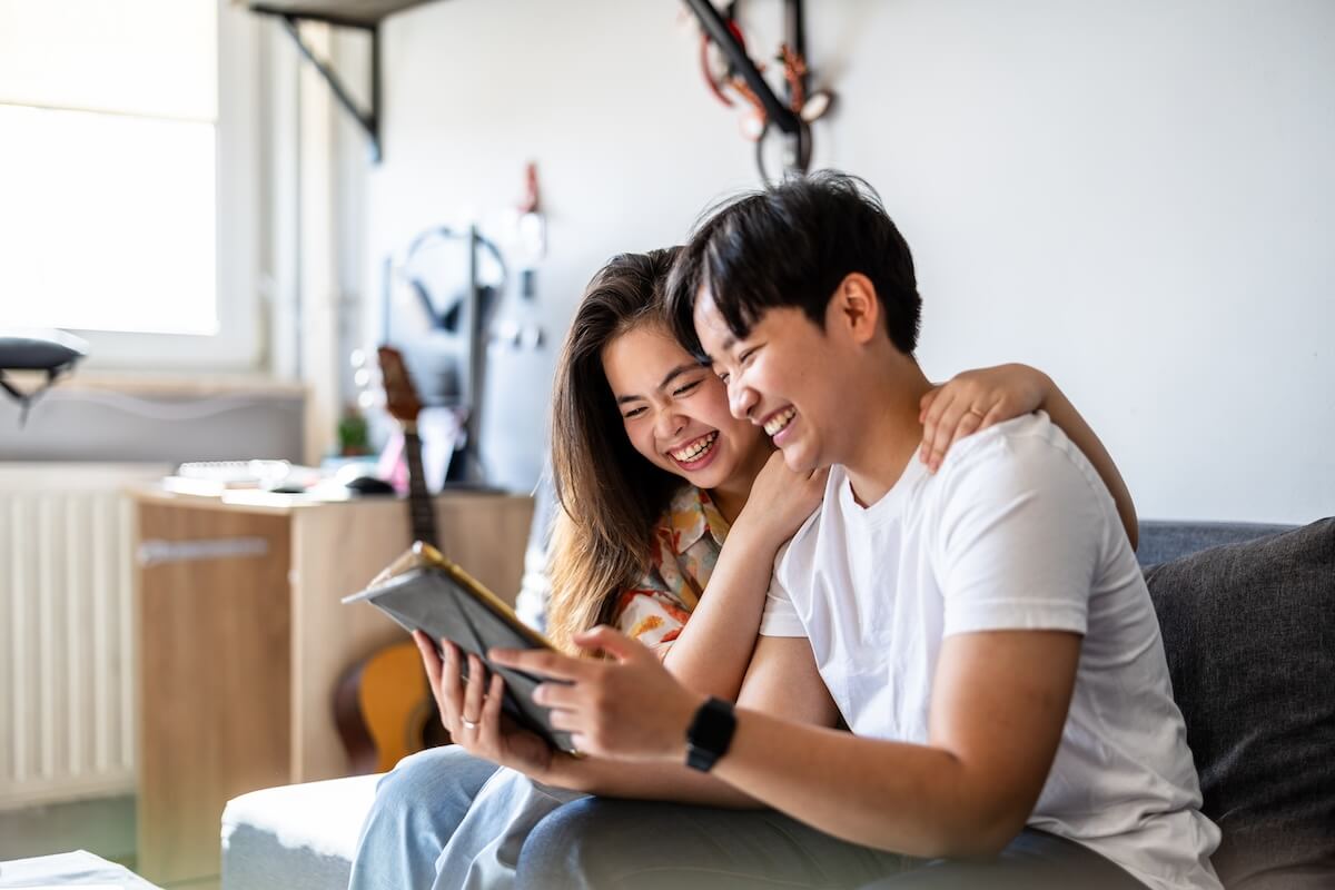Shutterstock: Happy young couple using digital tablet together on the sofa at home