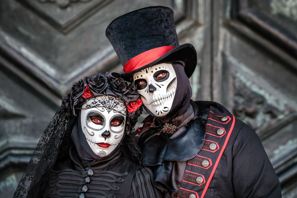 Shutterstock: Sugar skull masked dressed as married couple Day of the Dead style at Venice carnival, Italy.
