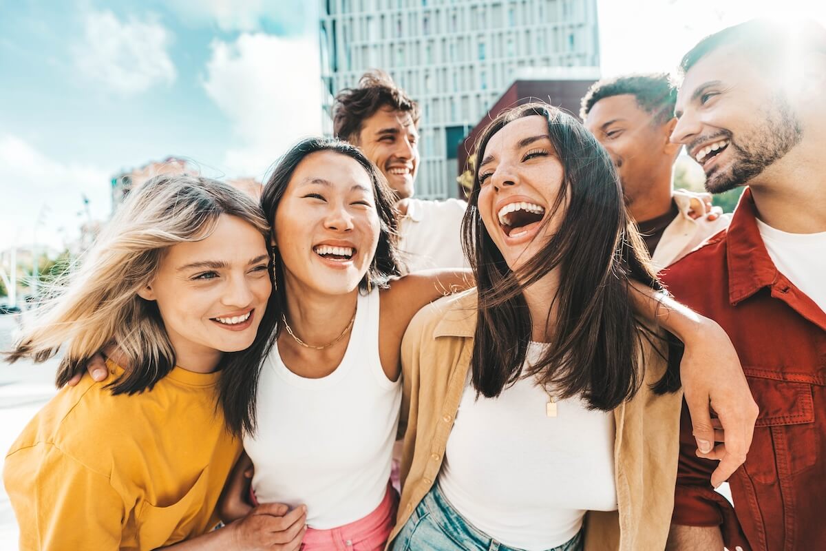 Shutterstock: Multiethnic friends having fun walking on city street - Group of young people enjoying summer vacation together - Friendship concept with guys and girls hanging outside on a sunny day