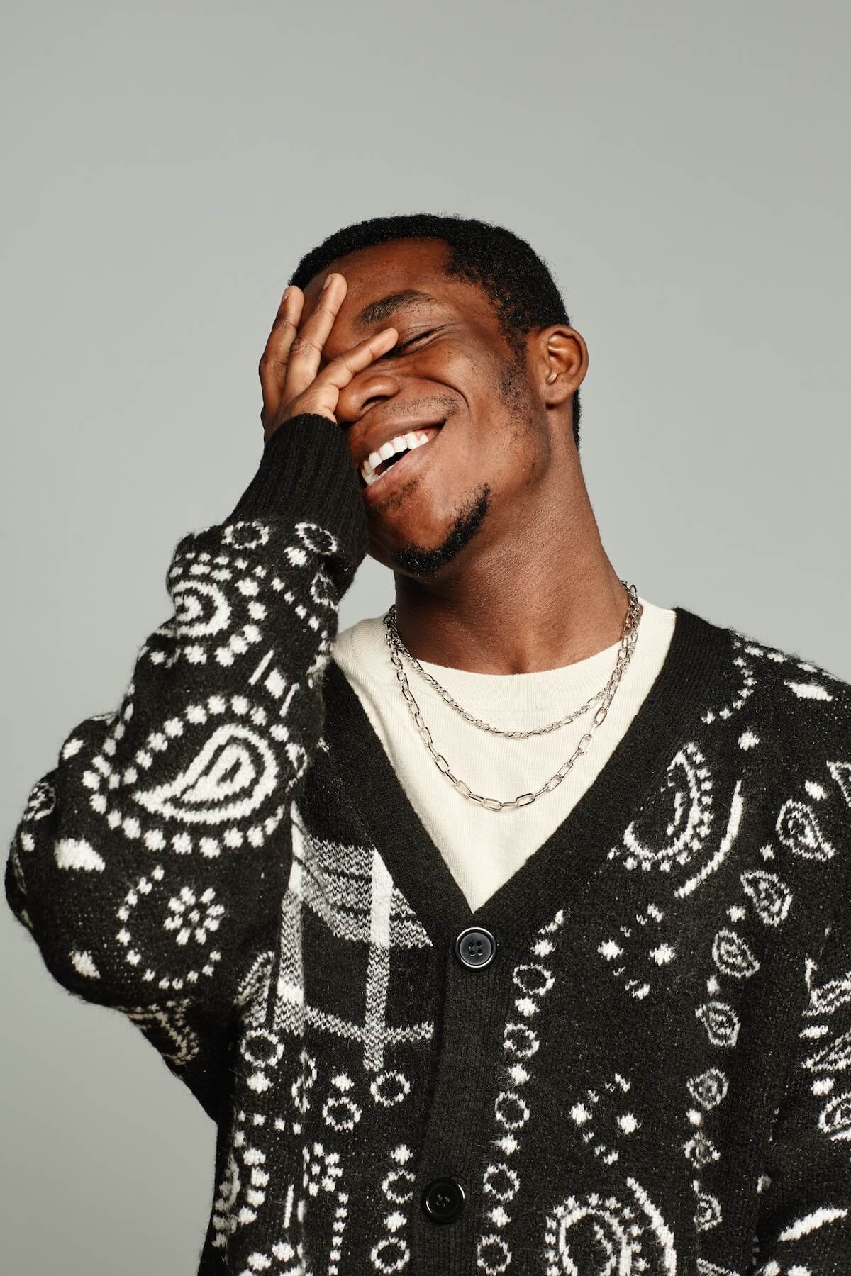 Shutterstock:Vertical waist up portrait of anonymous African American man wearing cardigan and laughing
