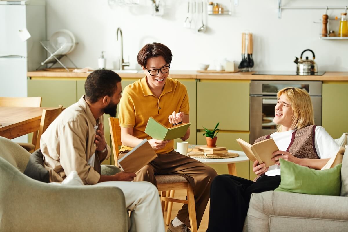 Shutterstock: Three young men share laughs and insights at a cozy book club in a stylish home.