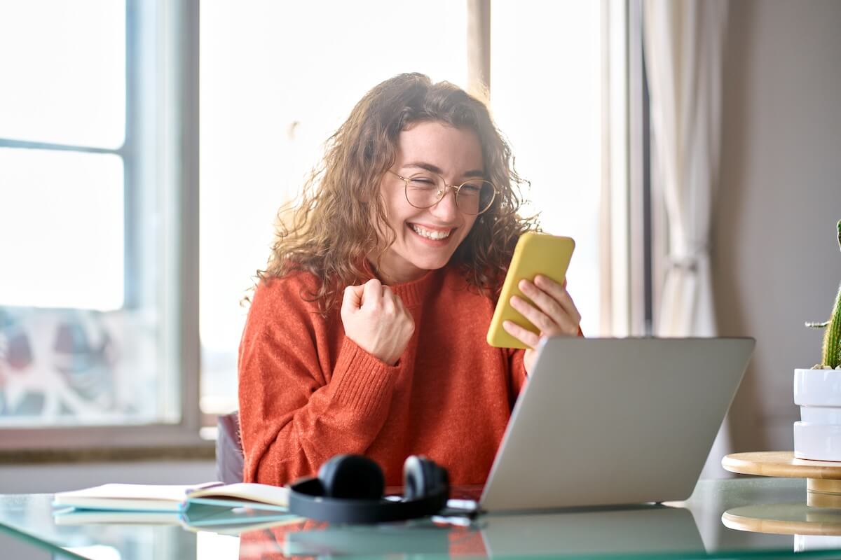 Shutterstock: Young happy lucky woman student feeling excited winner looking at cellphone using mobile phone winning online, receiving great news or sms offer, getting new job celebrating achievement.
