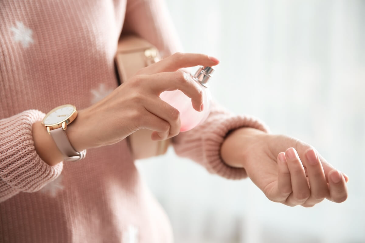 Shutterstock: Young woman using perfume indoors, closeup