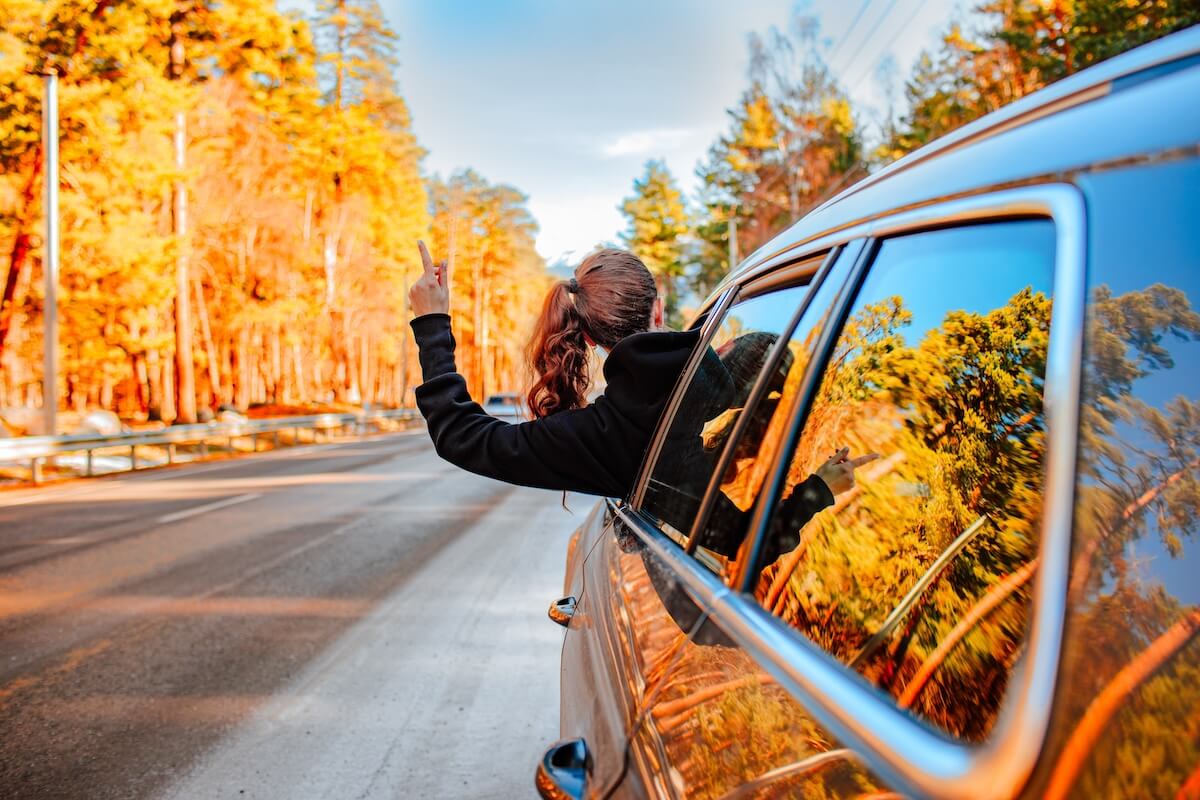 Shutterstock: Pretty young brunette woman travelling by car late autumn on the mountains road. Copy space. Travel concept