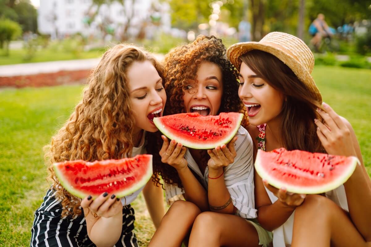 Shutterstock: Attractive young women eating watermelon In the park. People, lifestyle, travel, nature and vacations concept. Summer concept.