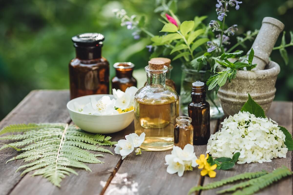 Shutterstock: Herbal pure organic essential oil, jasmine, camomile flowers on wooden background. Natural ingredients, apothecary plant-based treatment for relaxation, health care, anti-stress. Aromatherapy