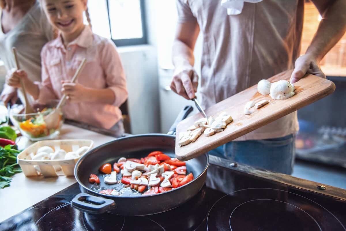 Shutterstock: Cropped image of cute little girl and her beautiful parents cooking together in kitchen at home