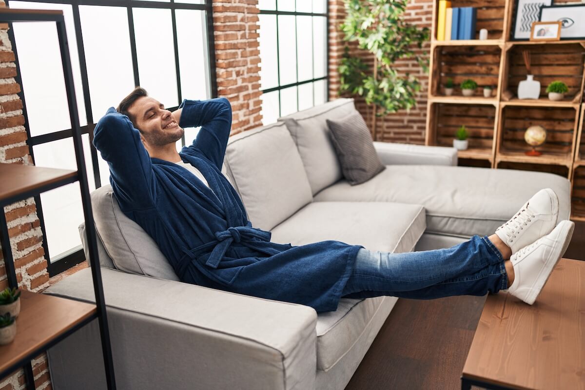Shutterstock: Young hispanic man wearing bathrobe relaxed with hands on head at home
