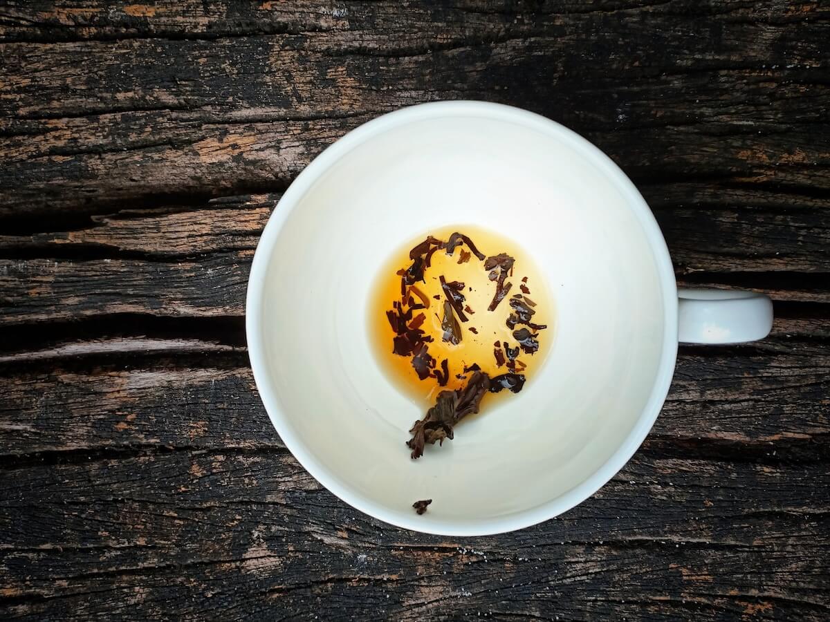 Shutterstock: Top view tea leaves at the bottom of a cup on wooden background