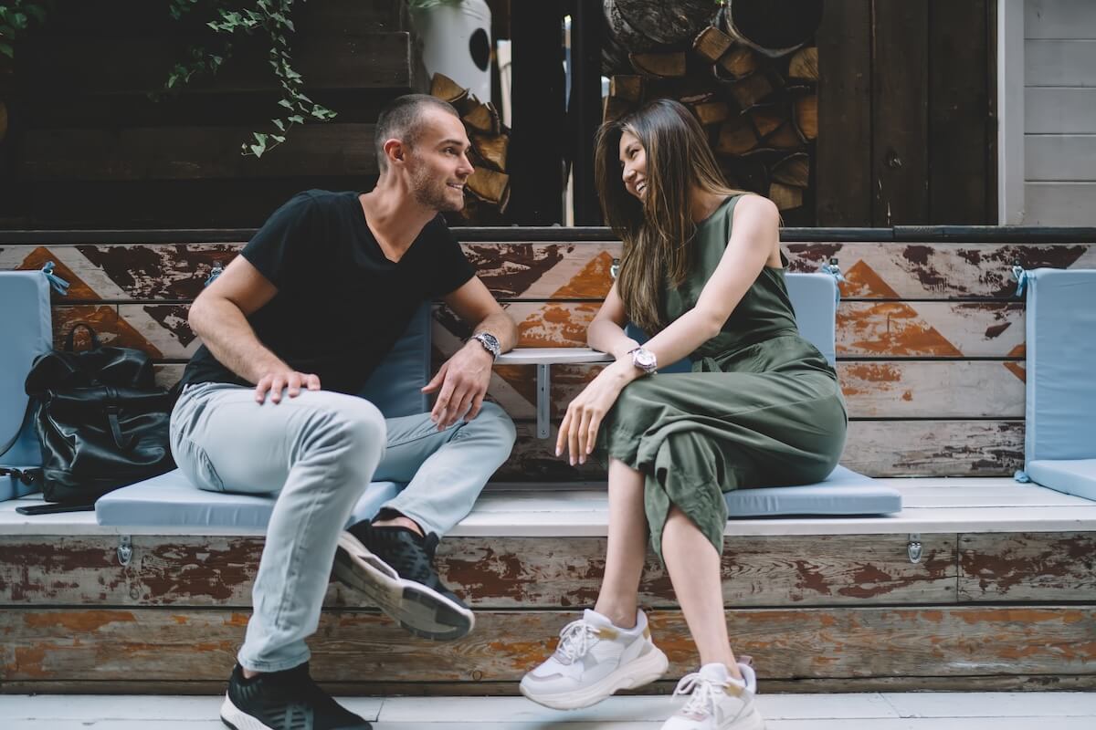 Shutterstock: Casual dressed male and female lovers enjoying time for flirting during date time in sidewalk cafe, happy diverse hipster guys discussing positive friendship and relationship smiling outdoors