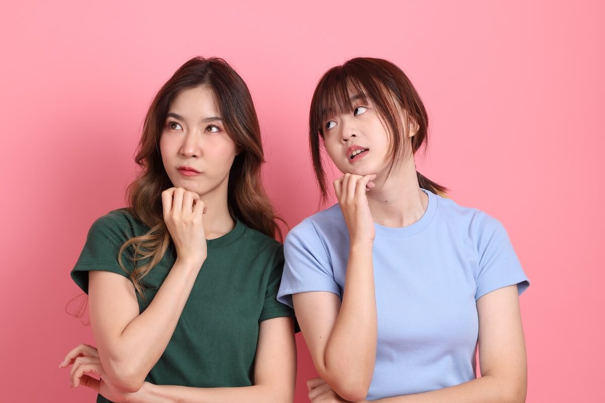 Shutterstock: Young adults friends, 20s East Asian women thinking on the pink background.