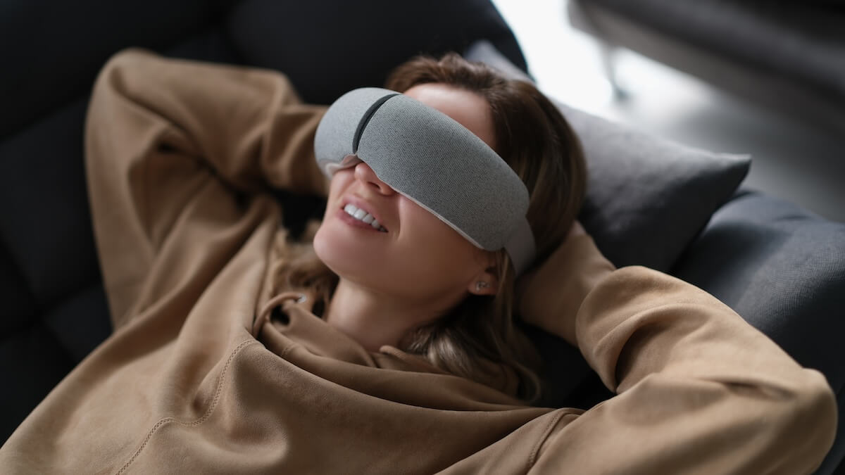 Shutterstock: Woman with eye massage device lying on sofa