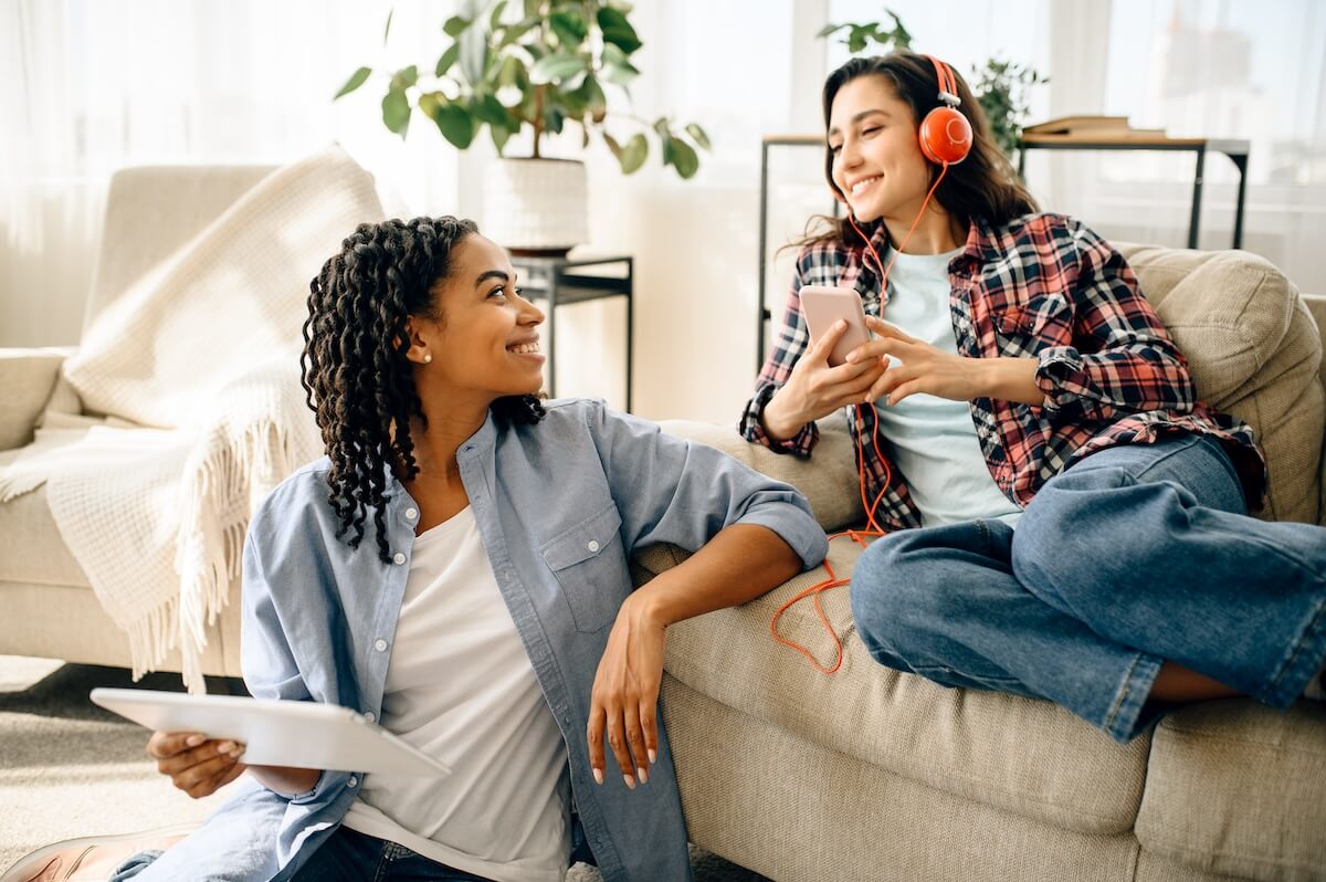 Shutterstock: Two women enjoys listening to music indoors