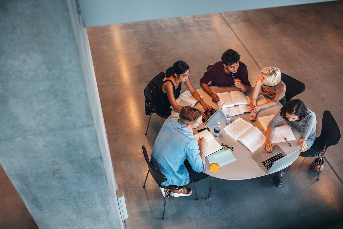 Shutterstock: Multiethnic group of young people studying together at a table. Young students in cooperation with their school assignment.