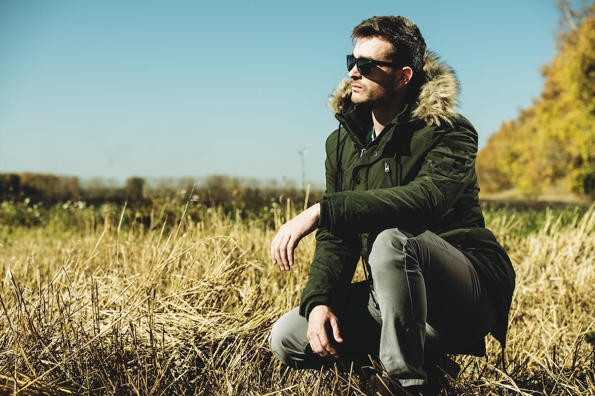 Shutterstock: A handsome brutal man wearing a parka and sunglasses in the countryside. Fashion for men. Autumn, winter.